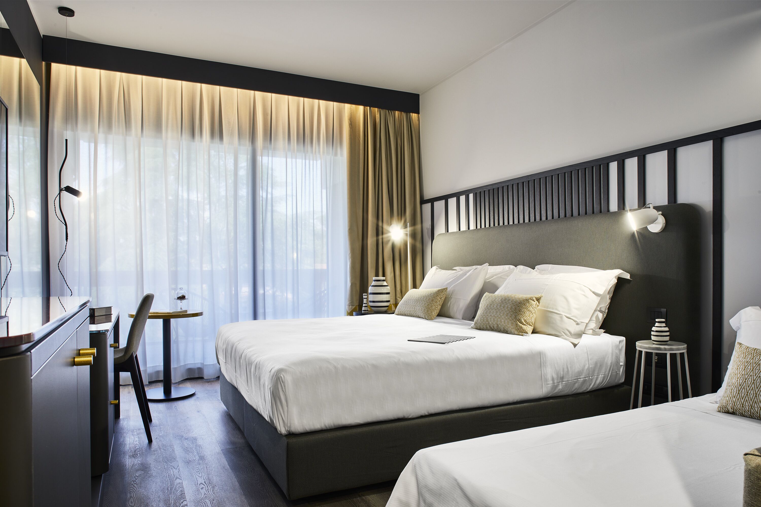 Une chambre d’hôtel moderne, dotée d’un grand lit, d’un bureau et d’une chaise.