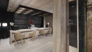 A modern kitchen with a wooden ceiling, a black backsplash, and a marble countertop. There are four beige chairs around the counter.