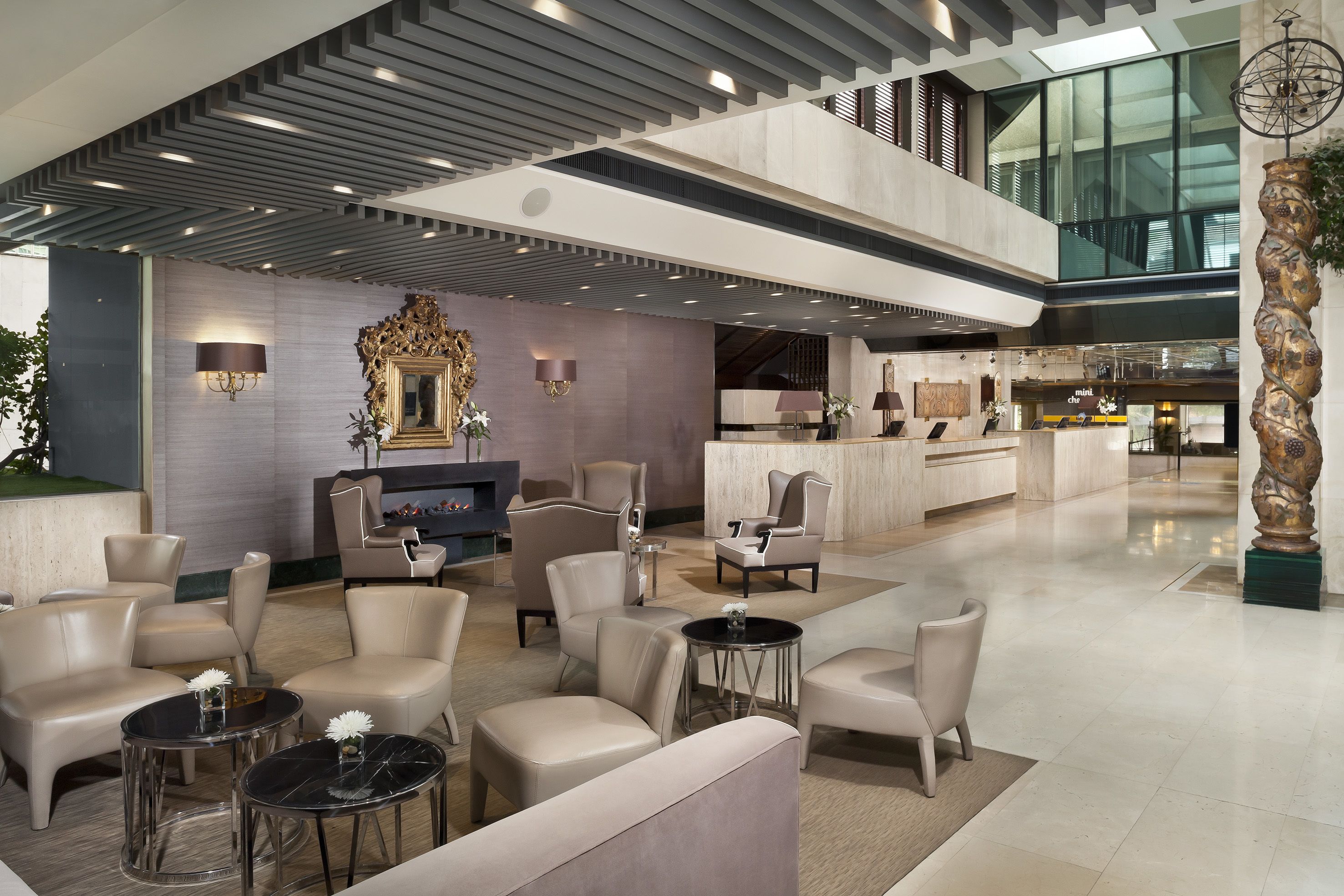 Un hall amplio con mobiliario moderno, una chimenea y vistas al área del restaurante.