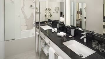 Un baño moderno con dos lavabos, un espejo grande y una ducha.