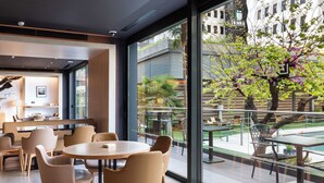 Ein modernes Interieur mit Essbereich, großen Fenstern und Blick auf die Terrasse.