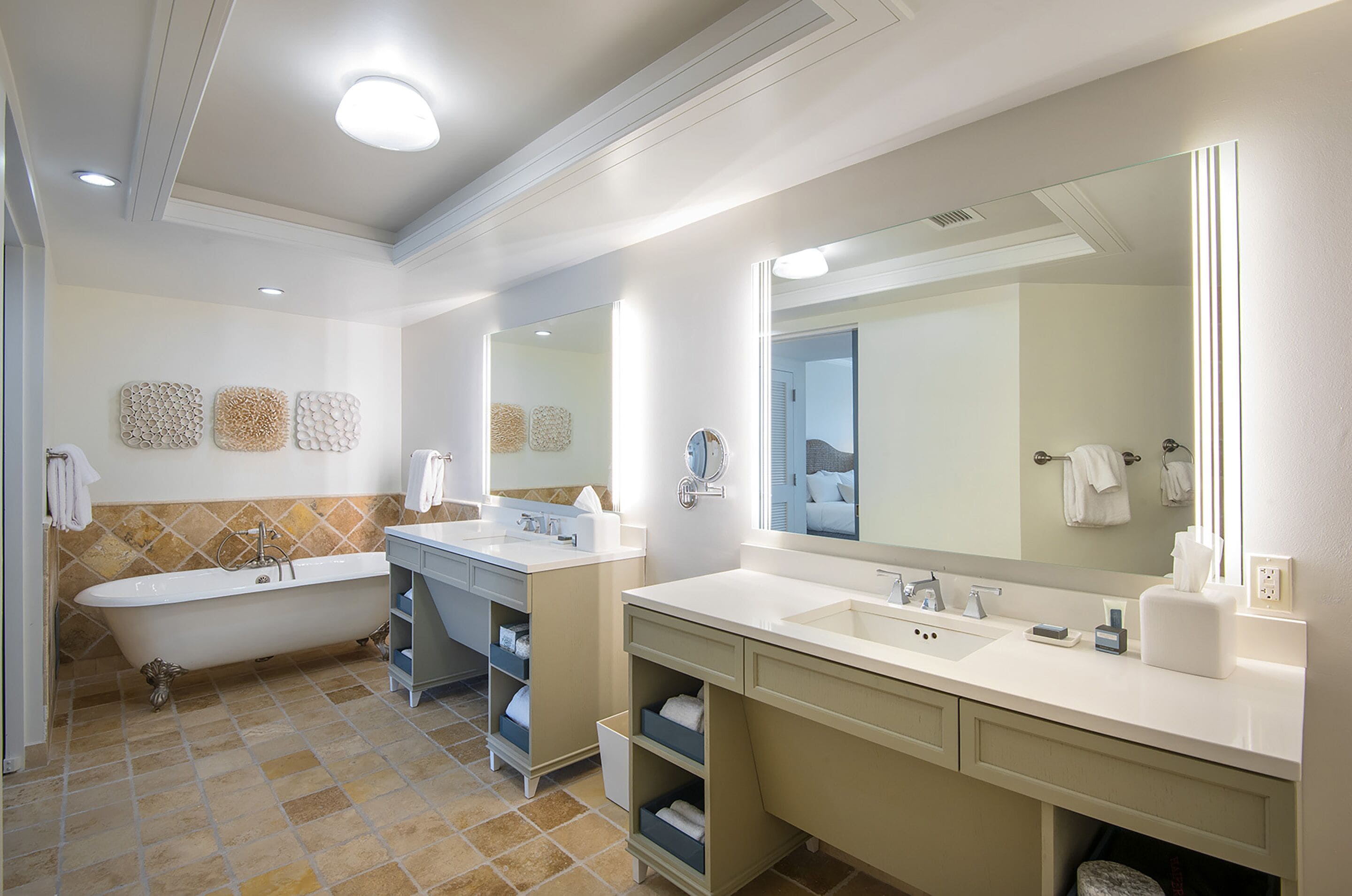 Une salle de bain moderne avec une baignoire sur pieds, deux lavabos et un grand miroir.