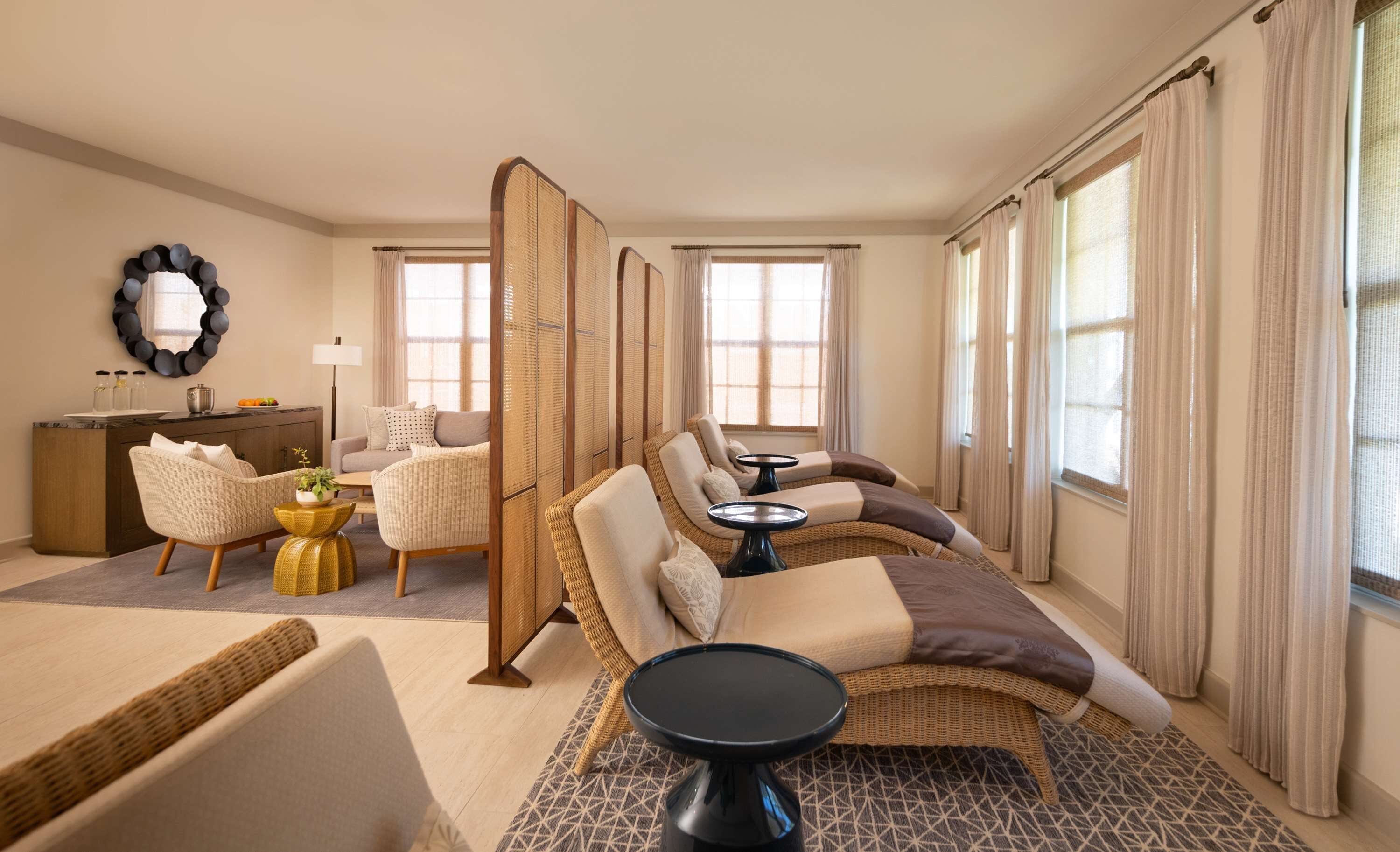 Une chambre d’hôtel moderne, dotée d’un canapé, d’une table à manger et d’une grande fenêtre avec des rideaux.