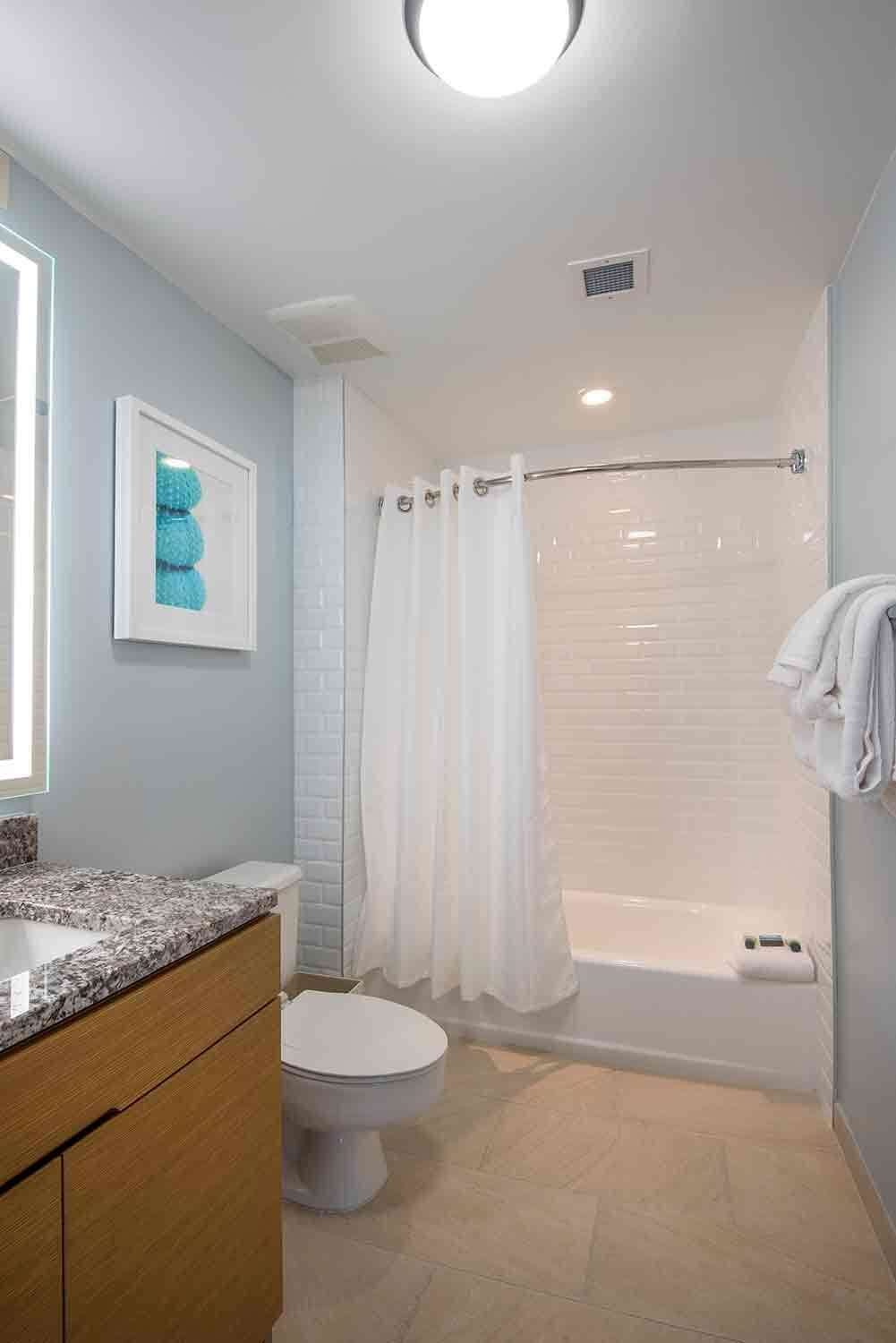 A bathroom with a toilet, a shower, and a sink.
