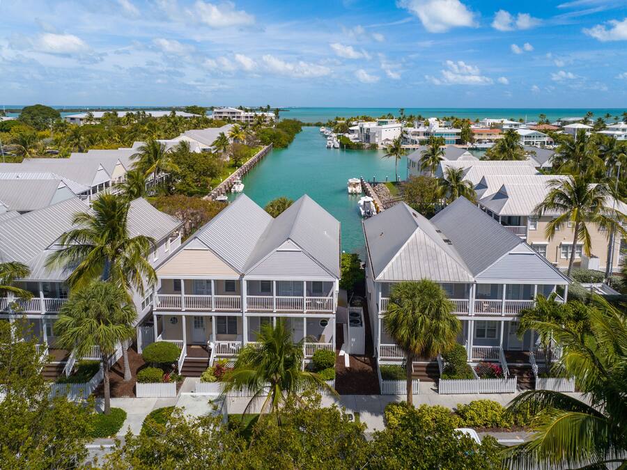 A coastal hotel with multiple buildings, a marina, and a clear view of the ocean.