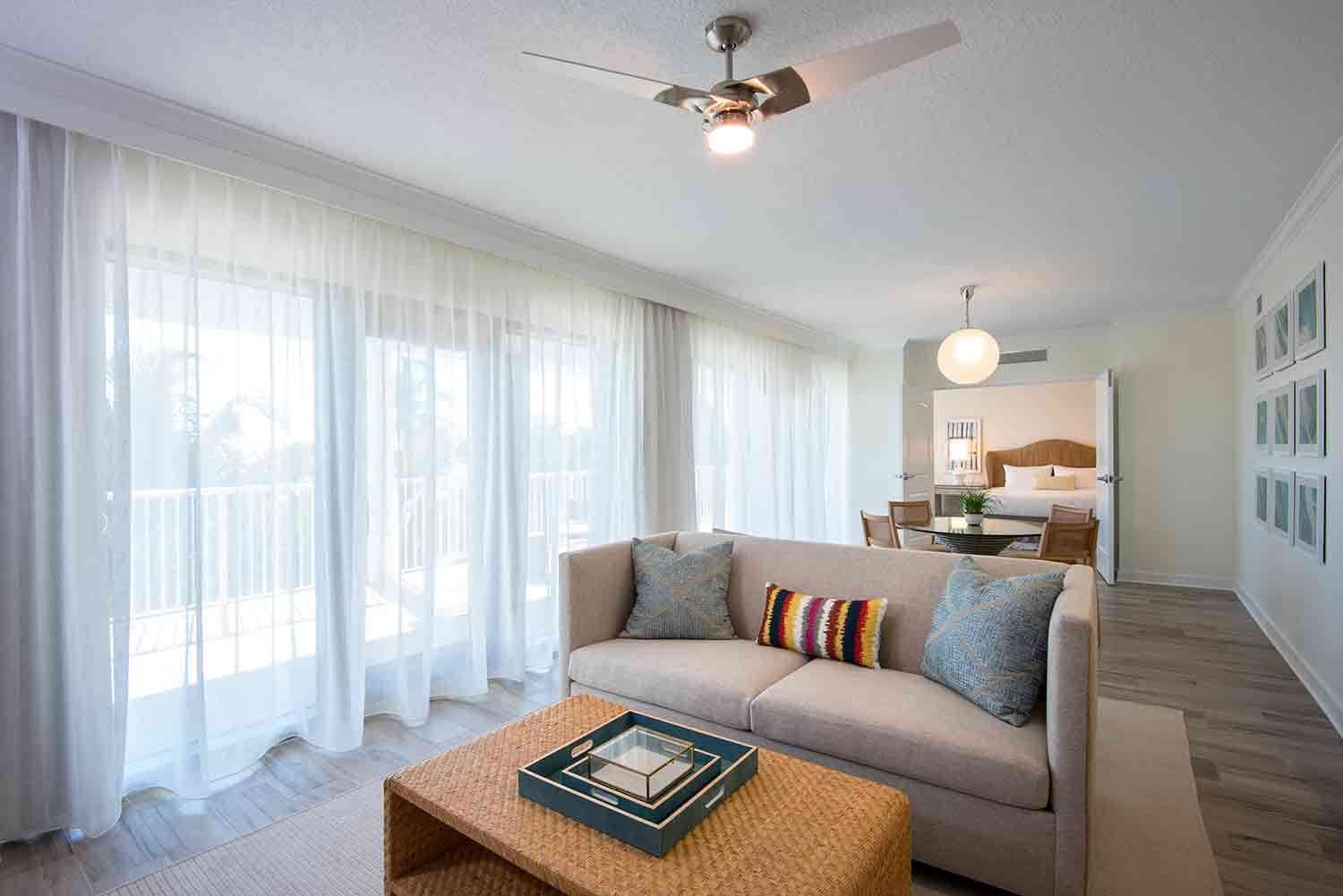 A modern living room with a sofa, a coffee table, and a ceiling fan.