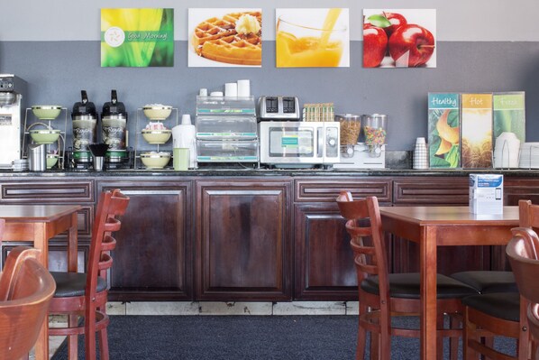A breakfast bar with seating, a coffee machine, and a toaster.