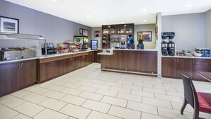 A modern kitchen with a central island, equipped with a coffee machine, a microwave, and a refrigerator.