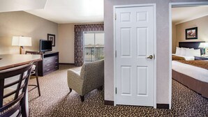 A hotel room with a desk, chair, television, and a bed.