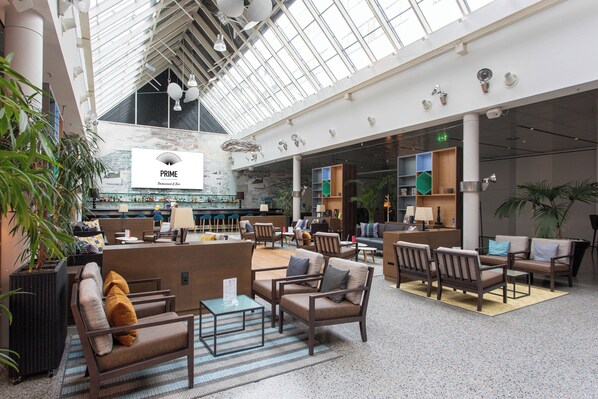 A spacious lobby with seating areas, a reception desk, and a large sign for 'PRIME'.