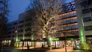 A Holiday Inn hotel with a large tree in front, multiple floors, and a modern architectural design. - Holiday Inn Berlin City West by IHG (Berlin)
