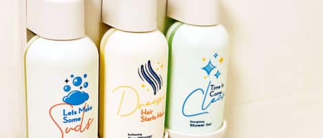 Trois bouteilles de produits pour les soins capillaires sont posées sur une étagère.