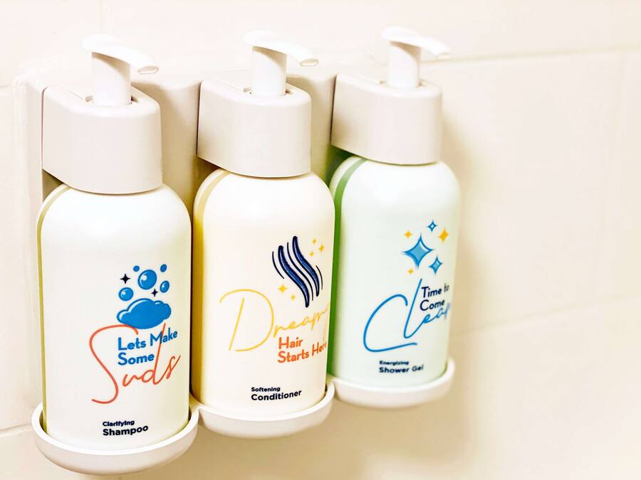 Three bottles of hair care products on a shelf.
