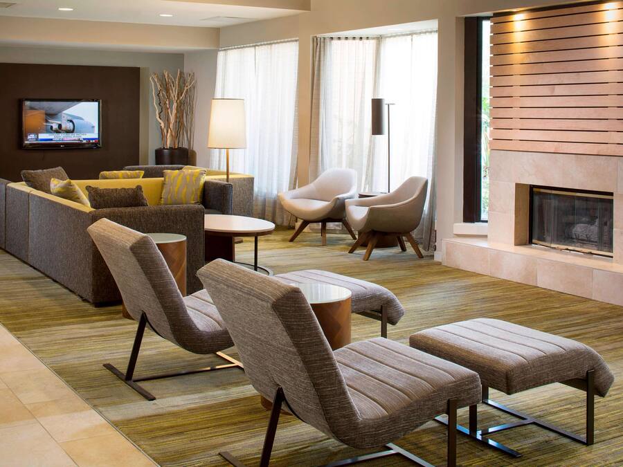 A modern living room with a sofa, armchairs, a coffee table, and a fireplace.