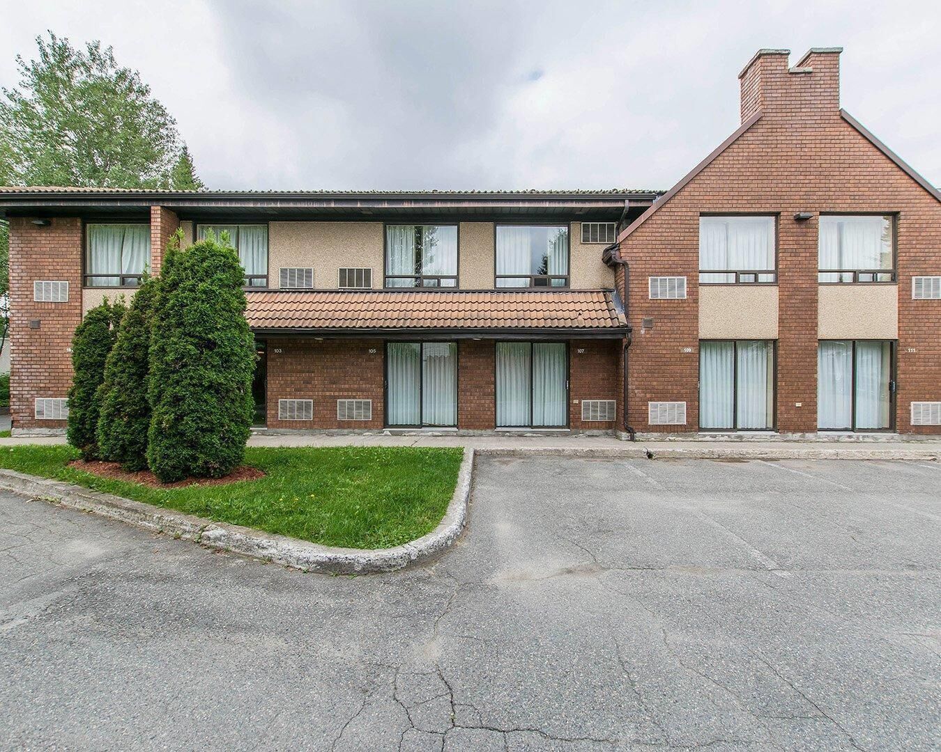 A two-story building with a flat roof, brick facade, and numbered windows.