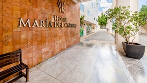 A hotel entrance with a marble floor, a bench, and a potted plant. - Hotel Maria del Carmen Merida (Mérida)
