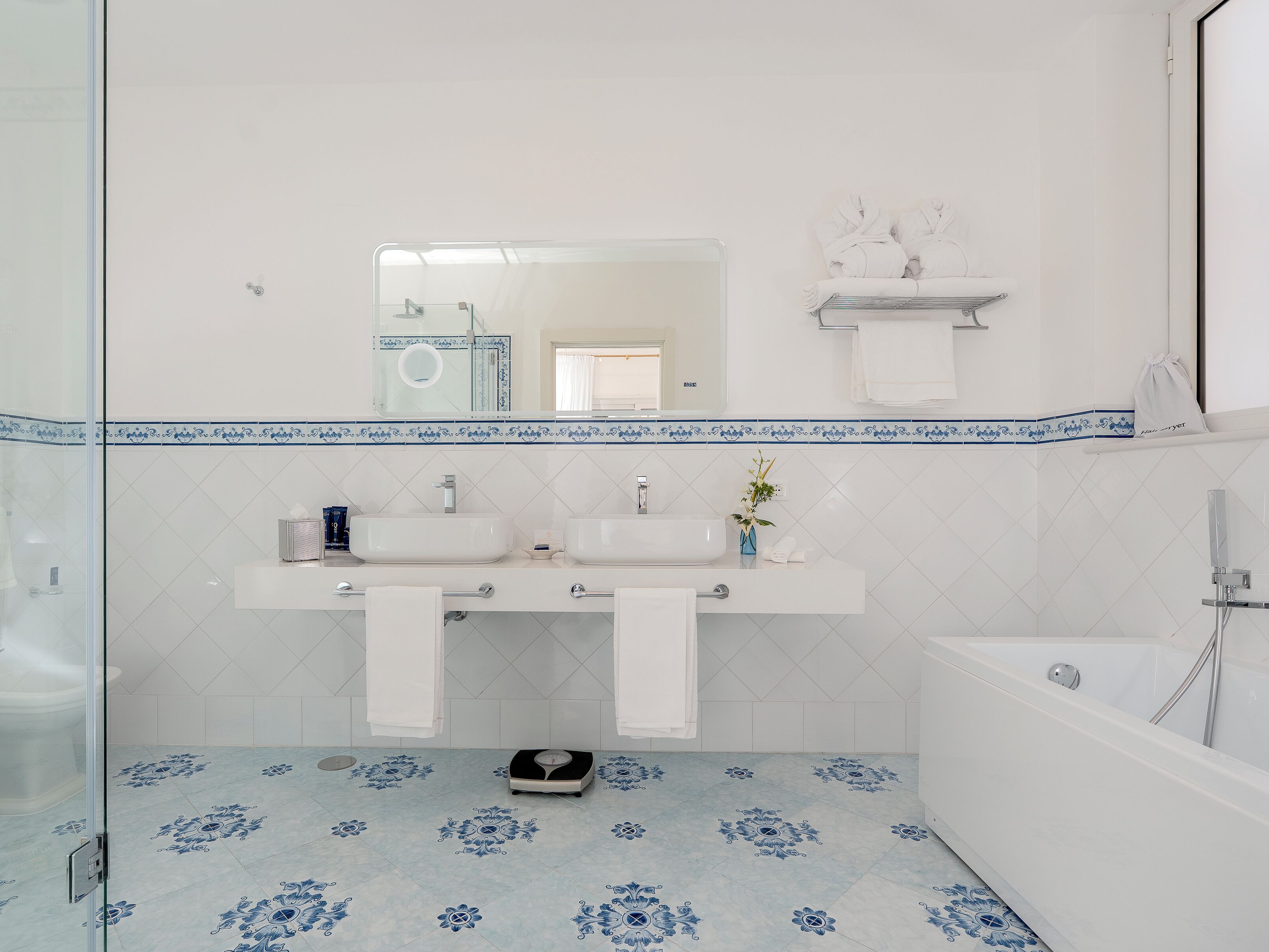 A bathroom with two sinks, a mirror, and a bathtub.