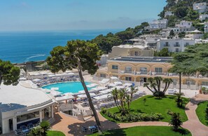A resort with a pool, outdoor seating, and a view of the sea. - Grand Hotel Quisisana (Capri)