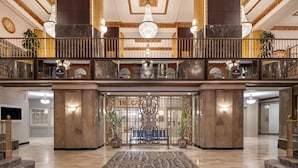 Eine beeindruckende Lobby mit Marmorboden, einer zentralen Bank und einer Wand mit einem Chandelier.