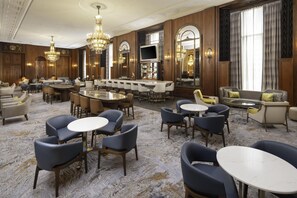 A spacious hotel lobby with multiple seating areas, a bar, and a television. - Hilton Milwaukee (Milwaukee)