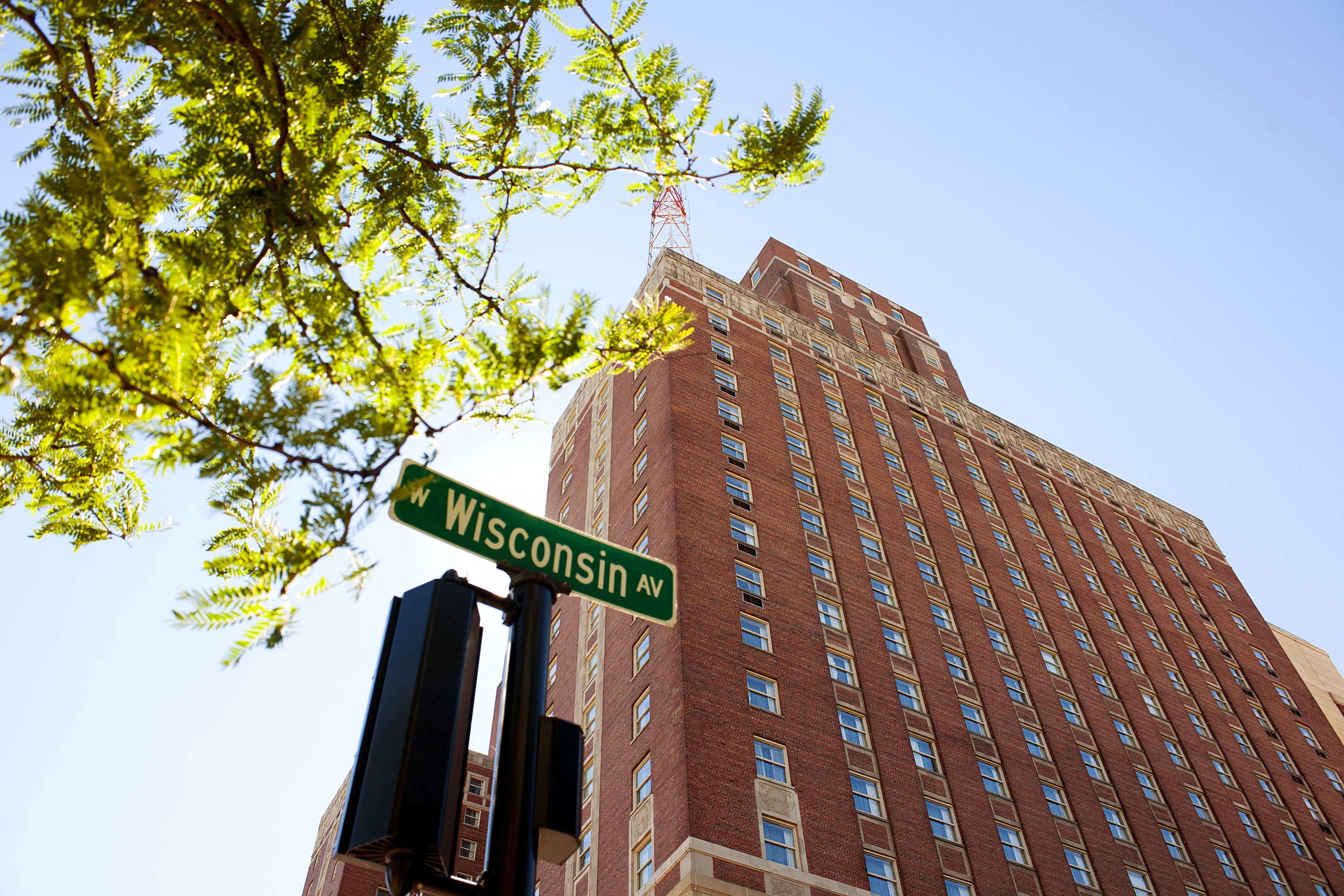 A tall brick building with a street sign reading "Wisconsin Ave."