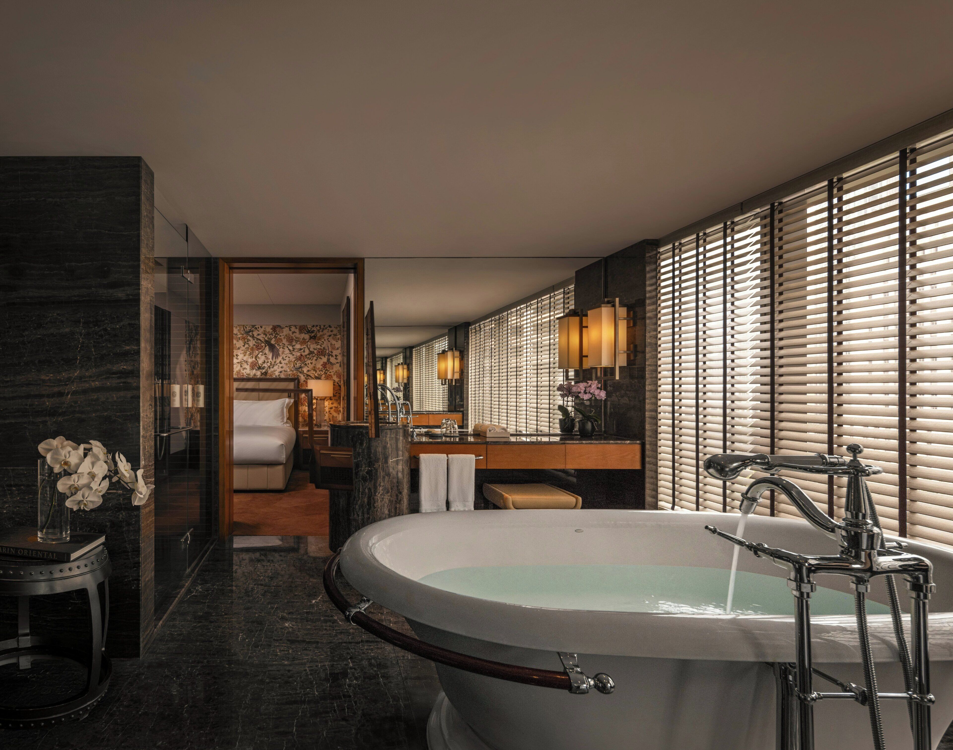 A modern bathroom with a freestanding bathtub, a vanity with a mirror, and a shower area.