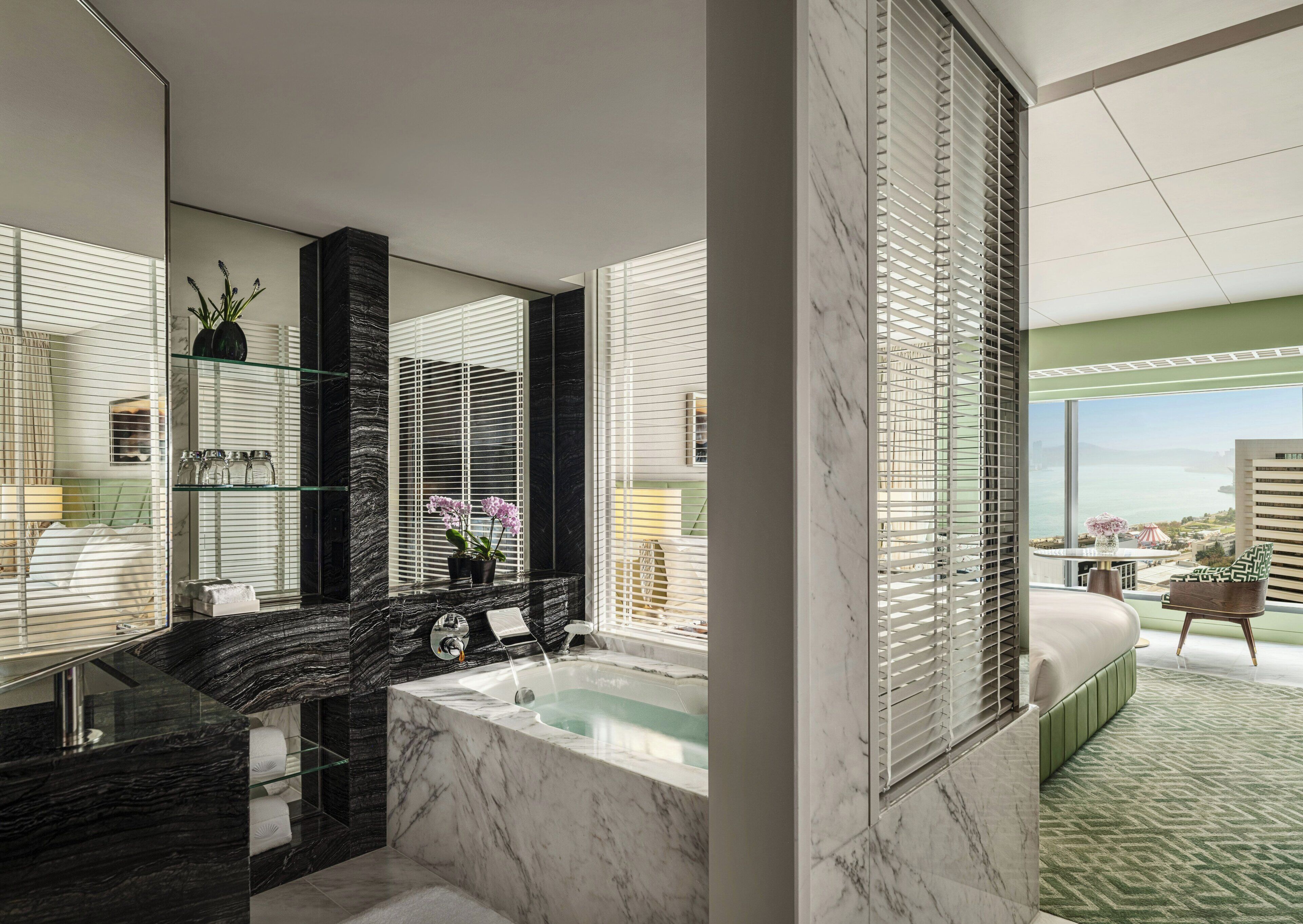 A modern bathroom with a marble sink, a bathtub, and a large mirror.