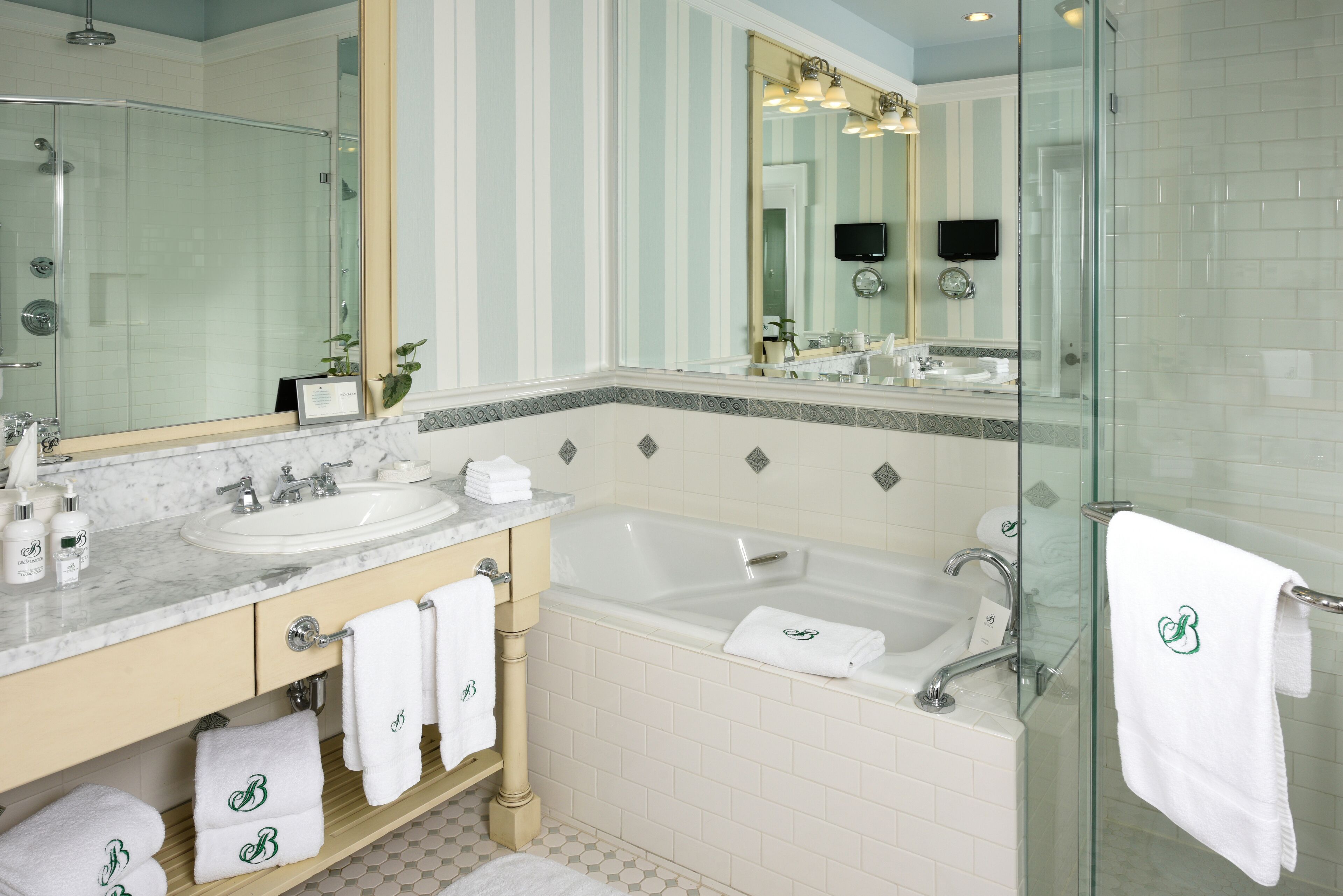 Ein modernes Badezimmer mit einer Duschkabine, zwei Waschbecken, einer Badewanne und einem großen Spiegel.