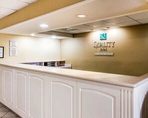 A reception desk with a logo for Quality Inn by Choice Hotels. - Quality Inn At the Mall - Valdosta (Valdosta)