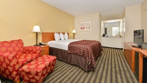 Ein Hotelzimmer mit Bett, einer Couch, einem Schreibtisch und einer Küchenzeile.