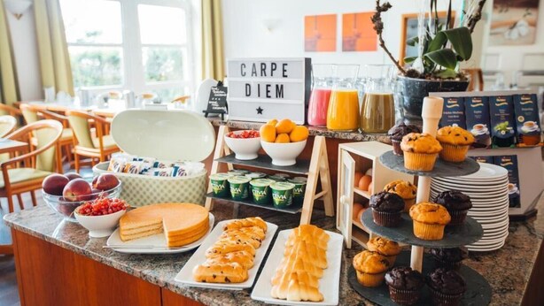 Un buffet de petit-déjeuner proposant une variété de viennoiseries, de fruits et de boissons.