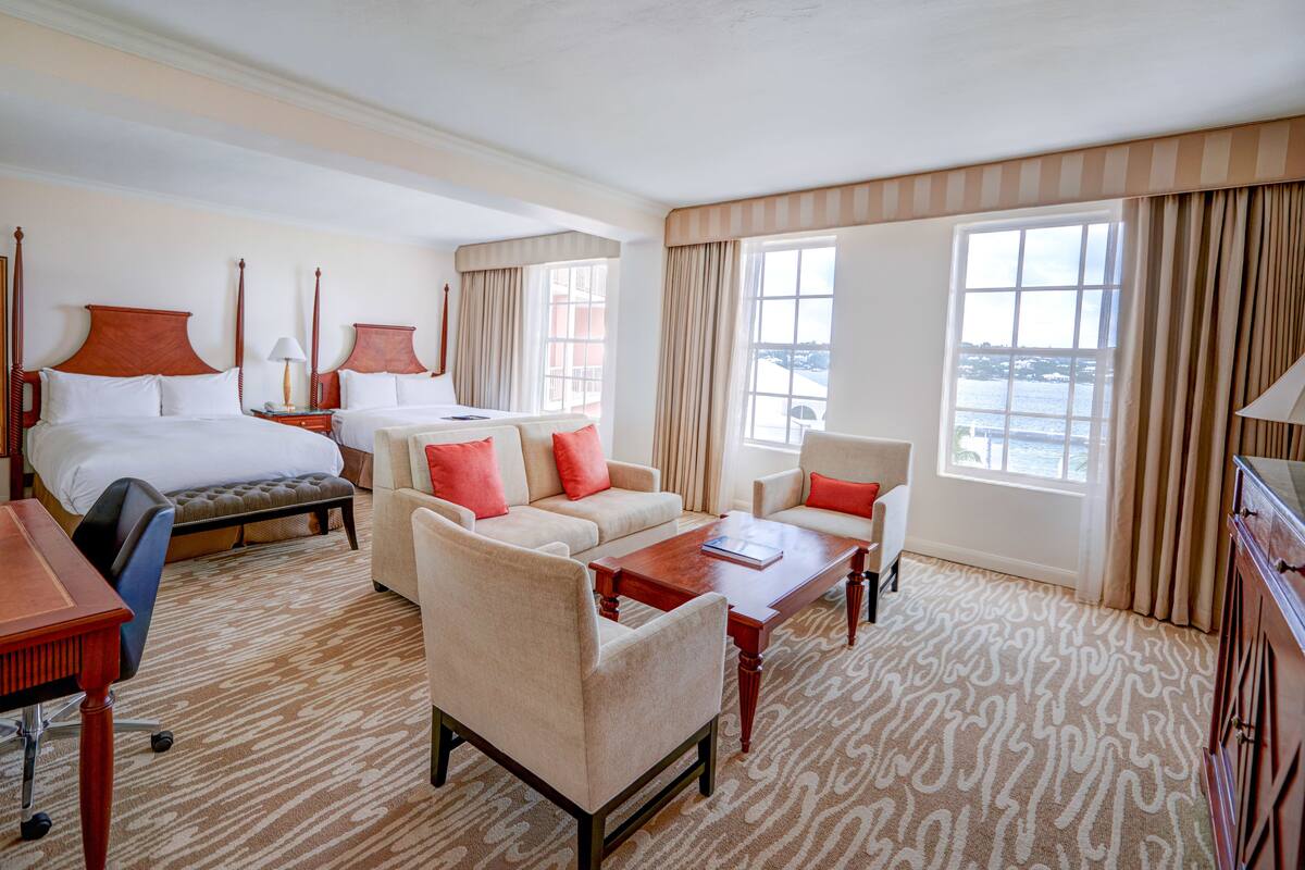 Ein Hotelzimmer mit einem großen Bett, zwei Sofas, einem Couchtisch und einem Schreibtisch.