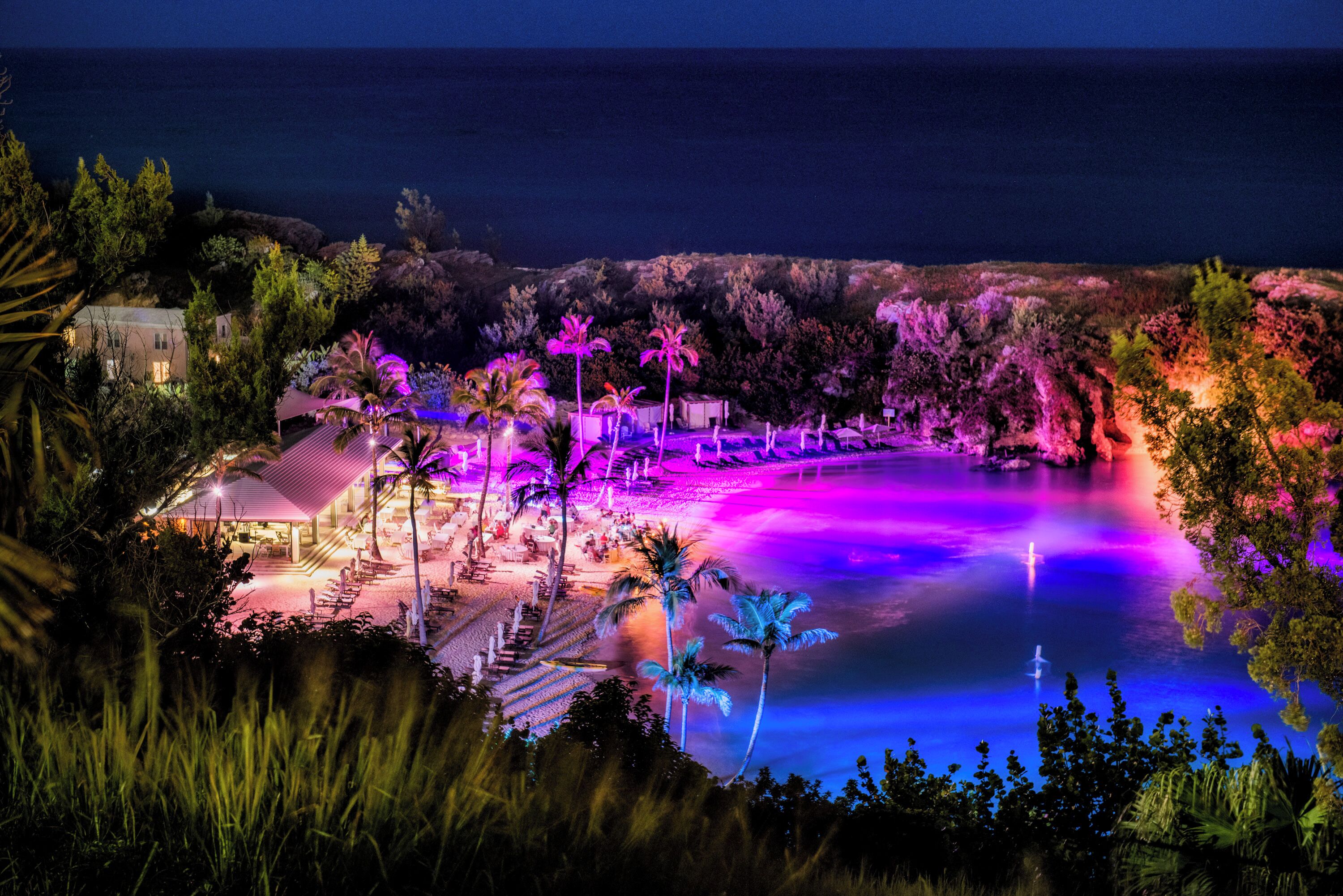 Un resort con piscina, palmeras y vista al océano.