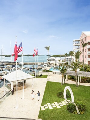 A marina with multiple boats, a pool, and a building with balconies.