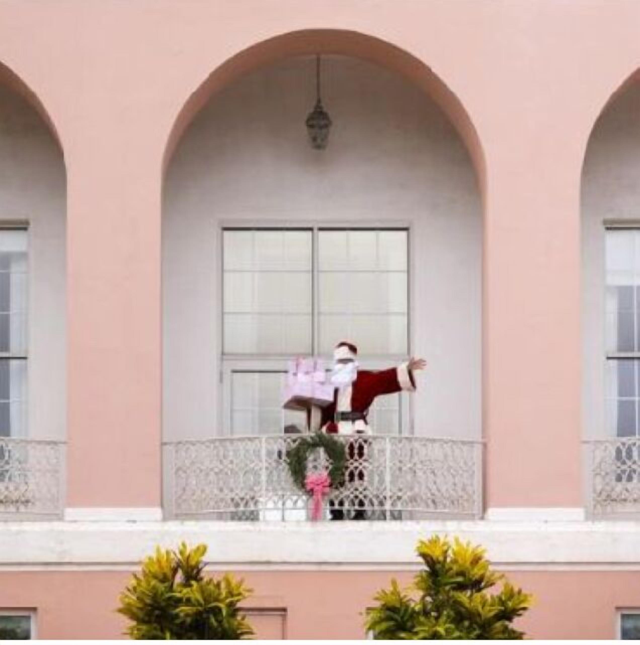 A building with a pink facade and arched windows.