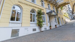 Ein gelbes Gebäude mit der Aufschrift "Heliopark Bad Hotel Hohenschönhausen" und einer Kopfsteinpflasterstraße.