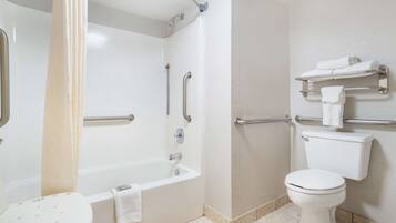 Een moderne badkamer met een bad, toilet en douche.