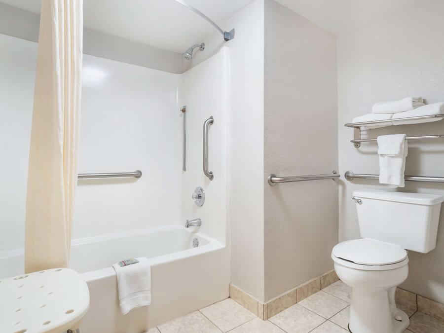 Een moderne badkamer met een bad, toilet en douche.