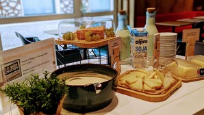 Ein Frühstücksbuffet mit verschiedenen Speisen und einem Schild, das die Herkunft des Brotes angibt.