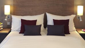 A hotel room with a large bed, two bedside tables, two wall-mounted lamps, and a wooden headboard. - Mercure Hotel Frankfurt Eschborn Ost (Eschborn)