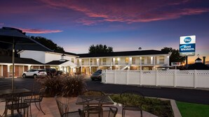 A motel with outdoor seating and a sign indicating it is the Best Western.