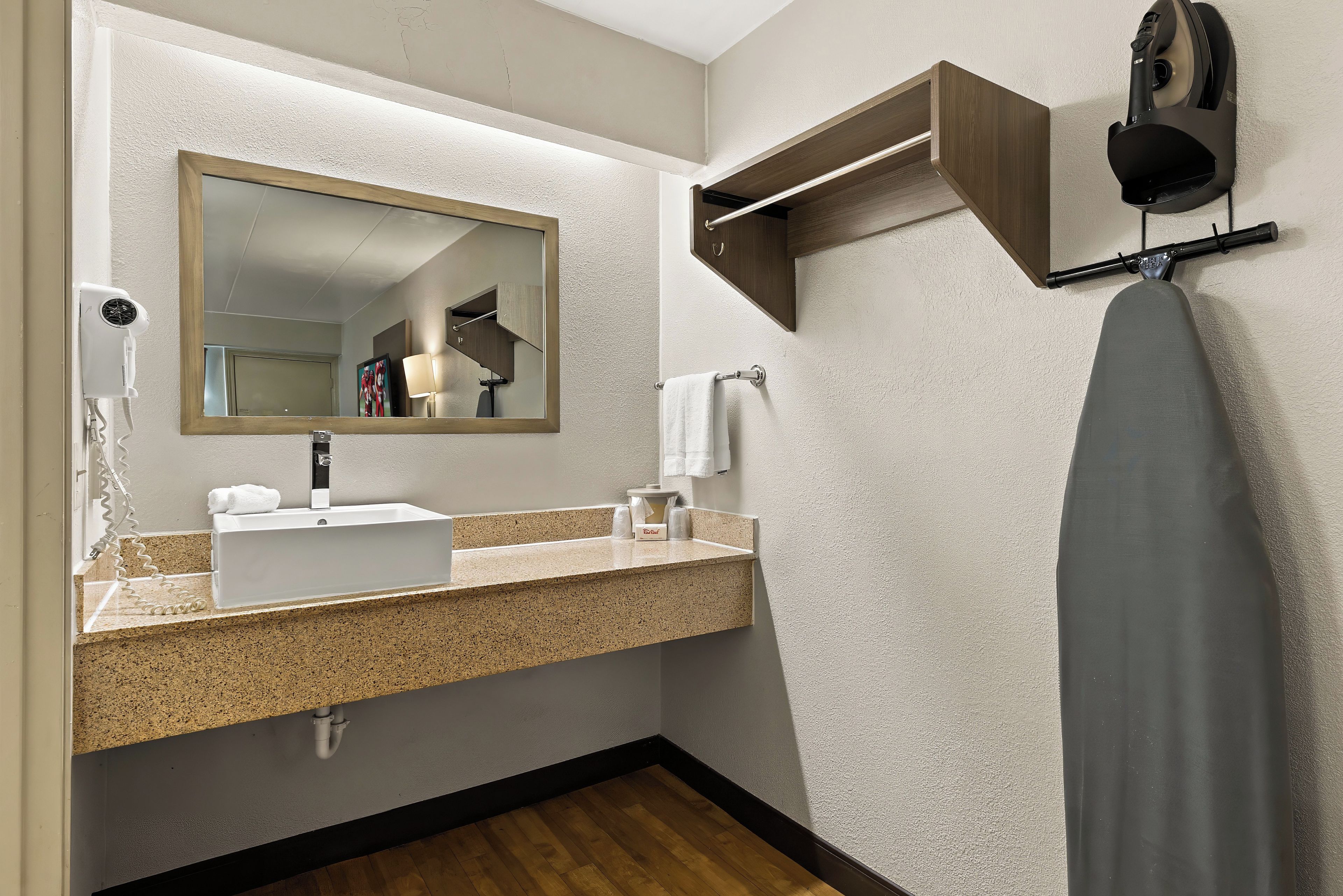 A modern bathroom with a sink, mirror, towel rack, and a hairdryer.