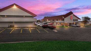 A Red Roof Inn with a parking lot and a grassy area in front.