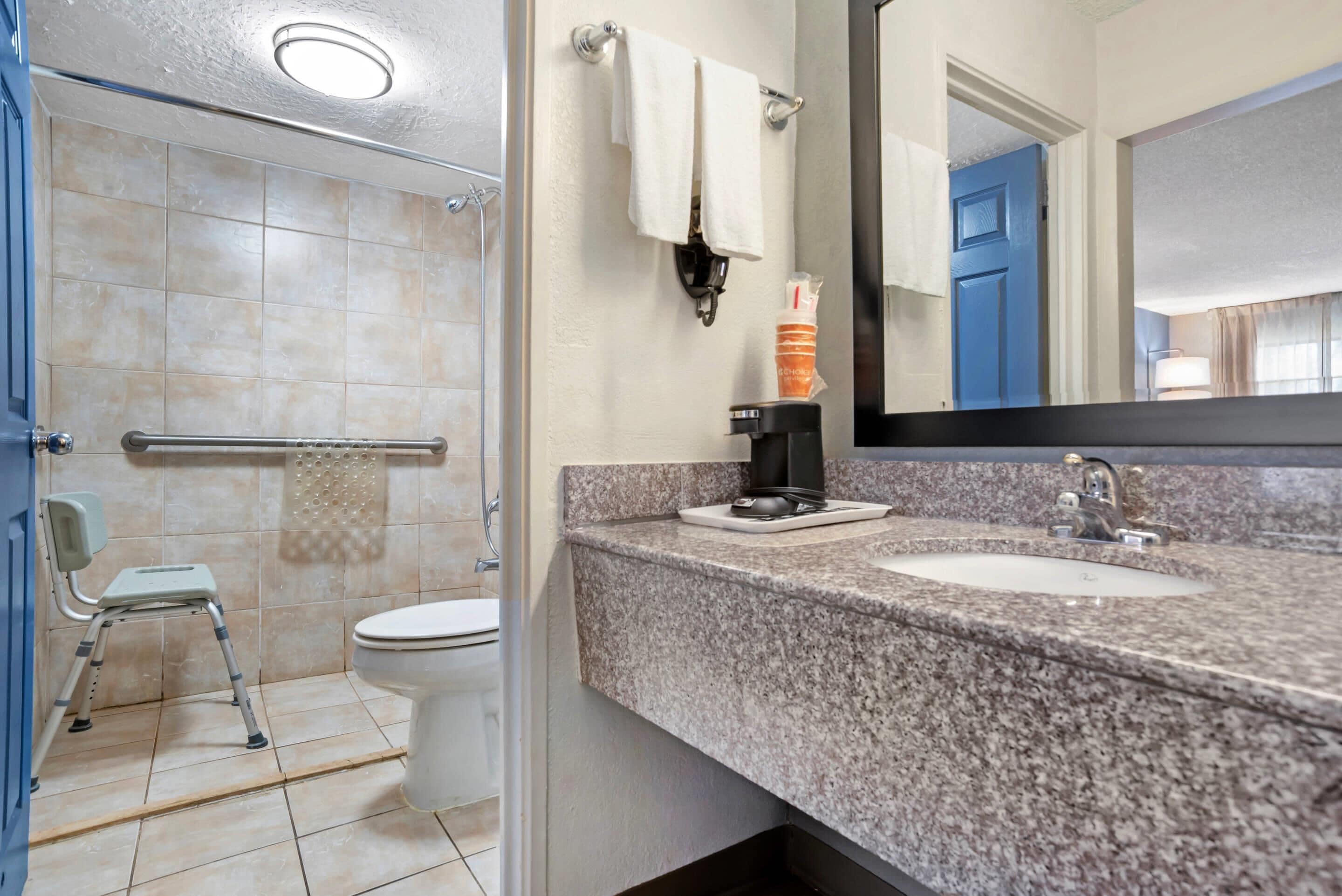 A bathroom with a shower, toilet, and sink.