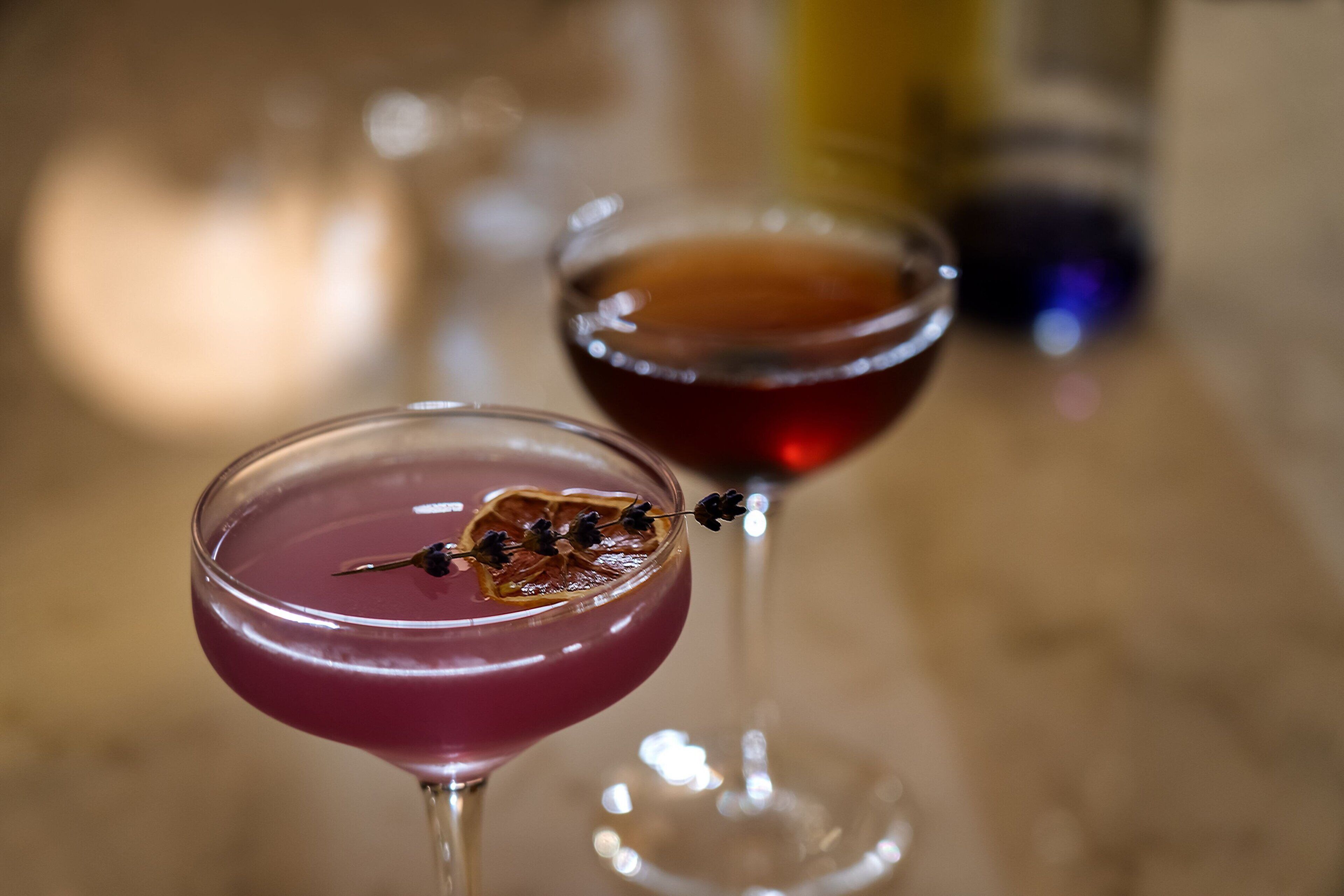 Two cocktail glasses on a wooden surface.