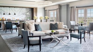A modern living room with a sofa, chairs, a coffee table, and a chandelier. - The Ritz-Carlton, St. Louis (St. Louis)