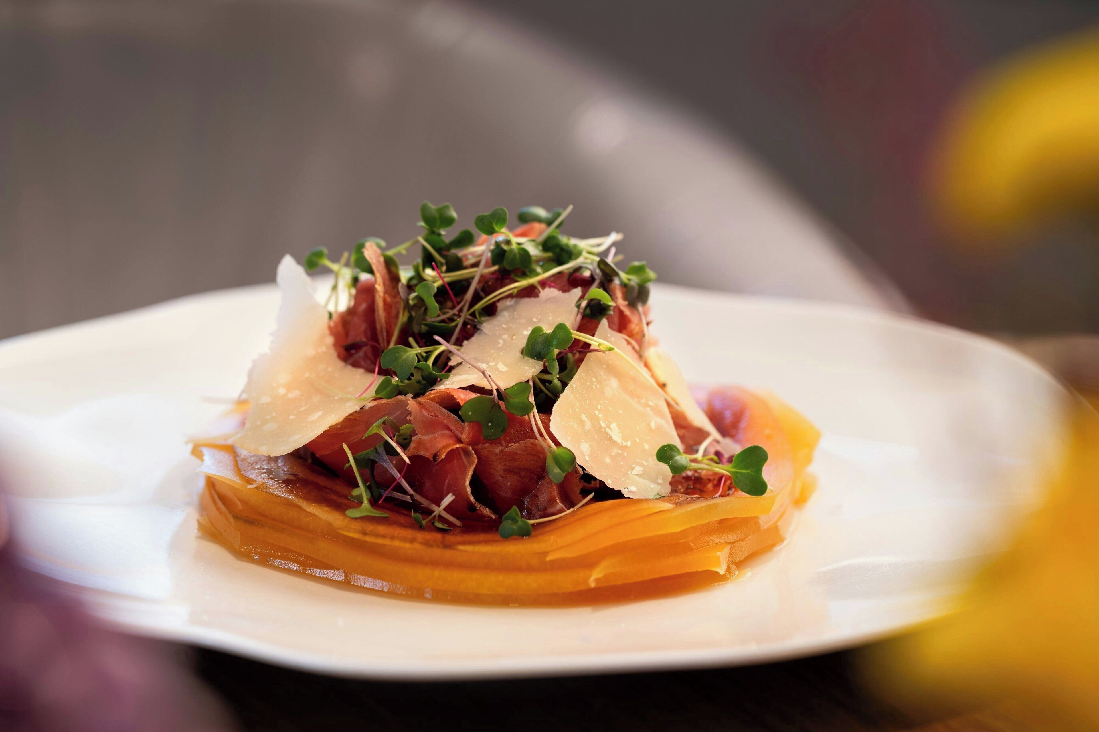 Une assiette de nourriture contenant divers ingrédients, notamment des légumes verts et, éventuellement, de la viande, le tout disposé sur une assiette blanche.