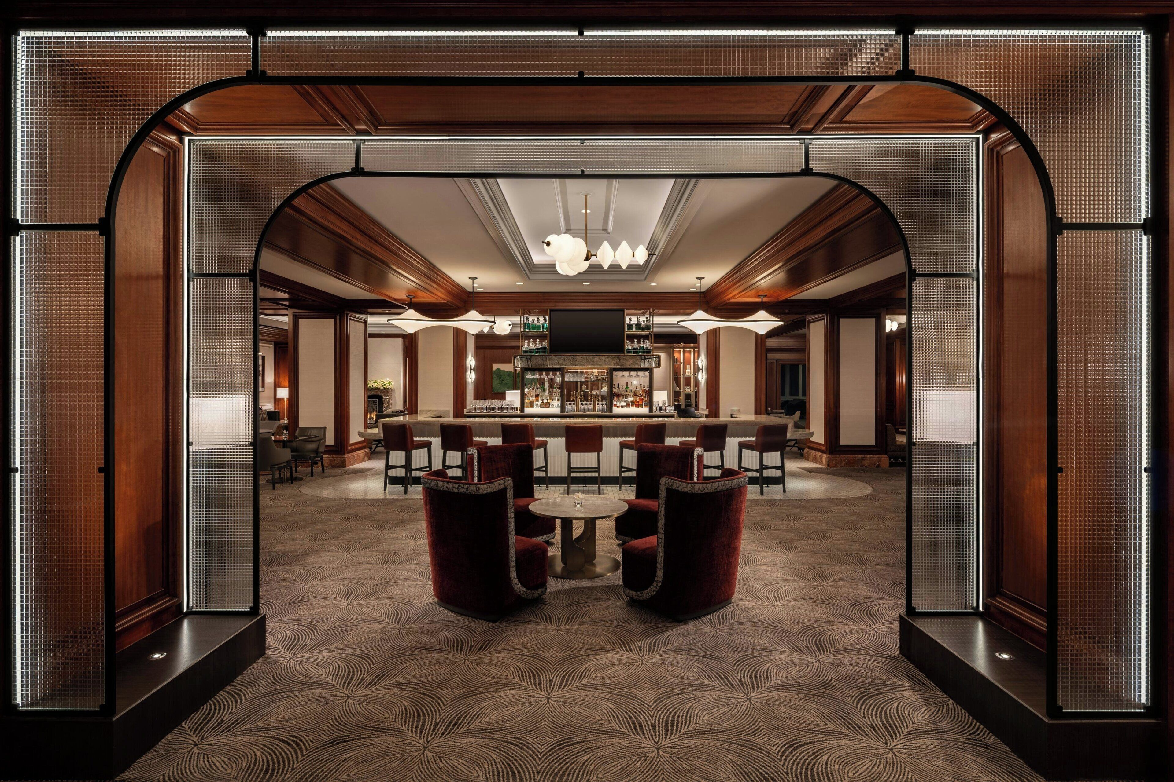 A lobby with a bar area, seating, and a patterned carpet.