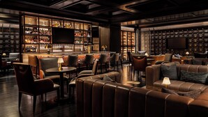 A bar area with leather seating, a bar counter, and shelves of bottles. - The Ritz-Carlton, St. Louis (St. Louis)
