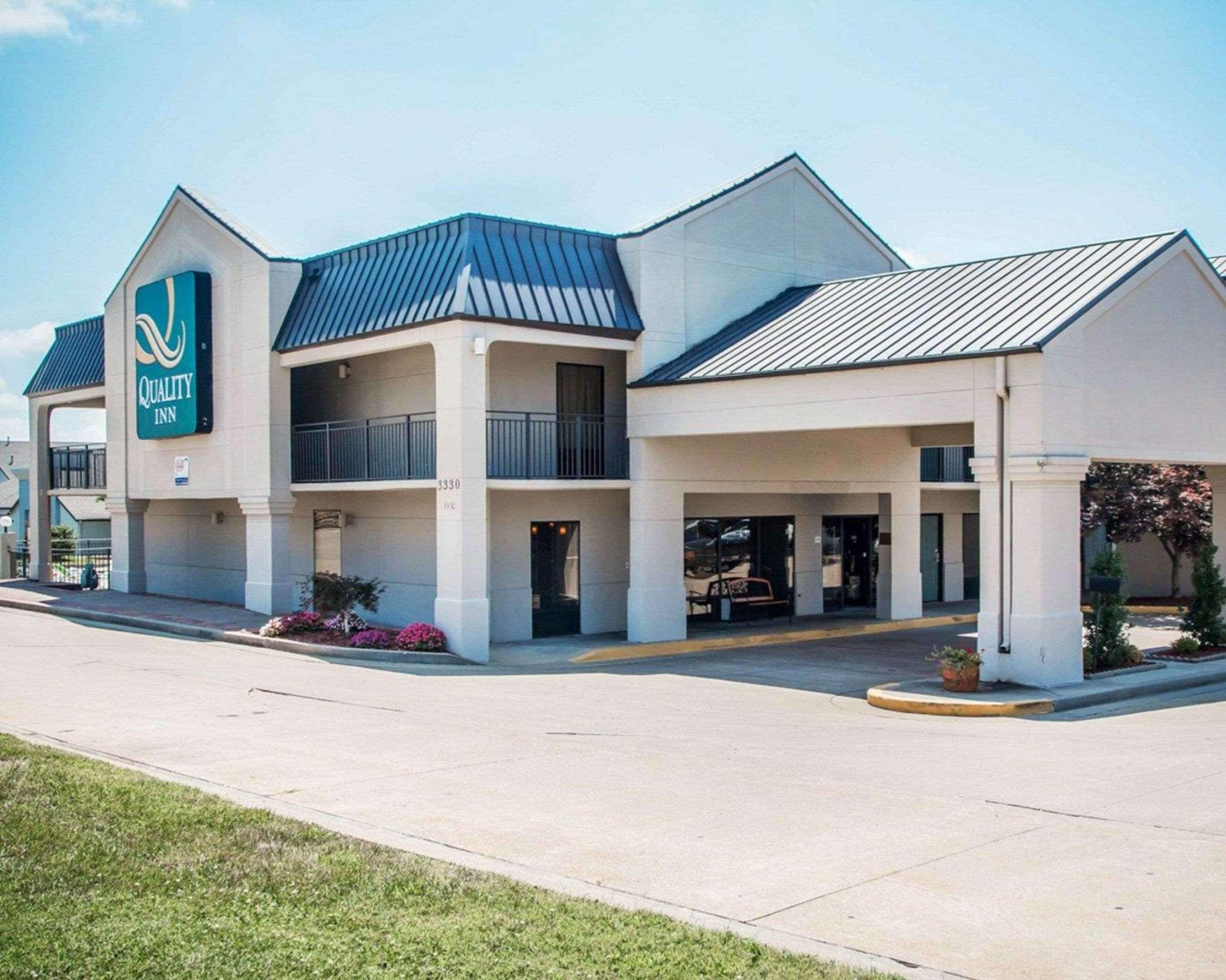 A two-story Quality Inn with a modern design, featuring a flat roof and a prominent sign.